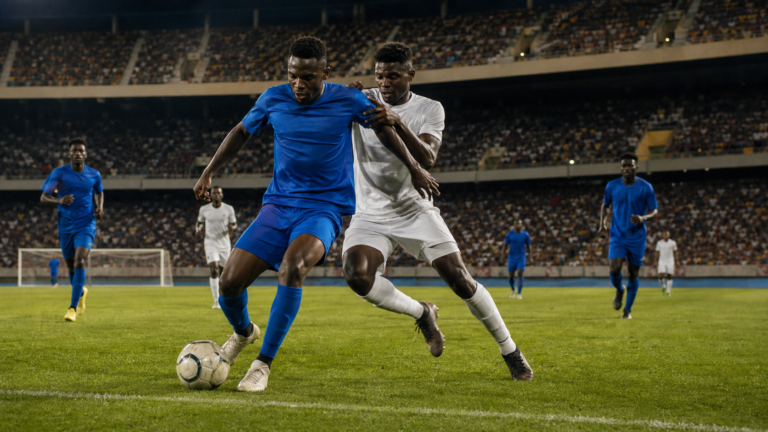 Players contest the ball during a men’s club football match